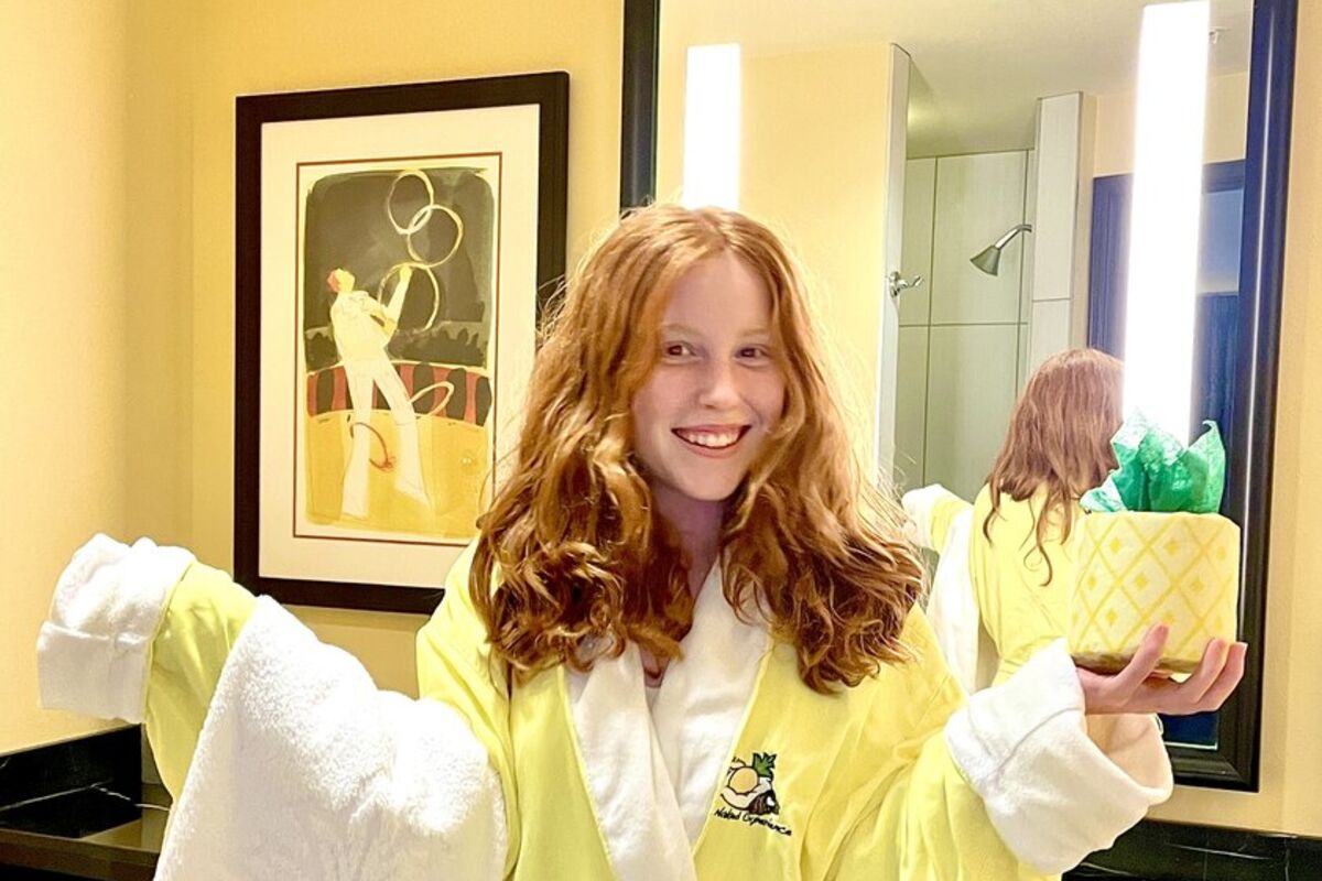 Girl%20in%20yellow%20bathrobe%20in%20bathroom%20holding%20towel%20and%20T%2EP%2E%20wrapped%20like%20a%20pineapple%2E