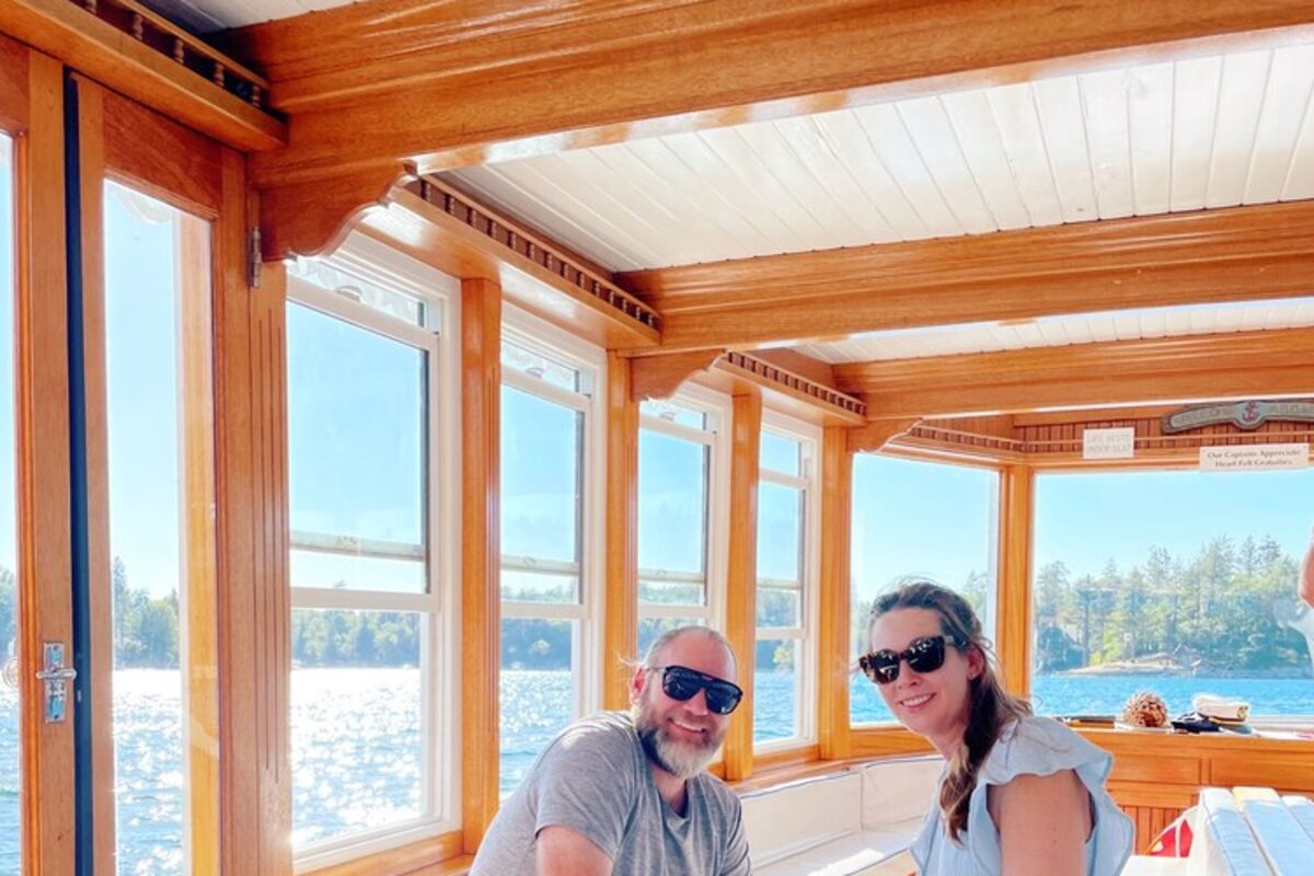 A%20couple%20and%20dog%20sitting%20on%20a%20boat%20in%20a%20lake%2E
