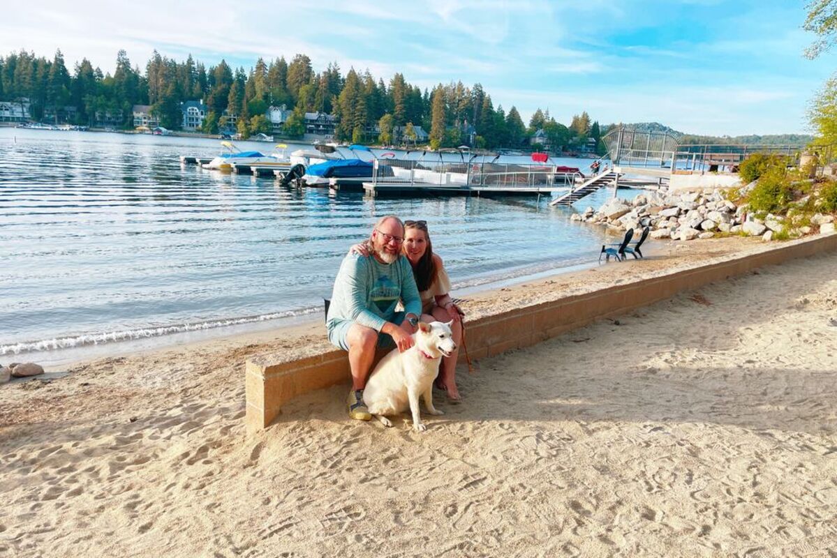 couple%20sitting%20on%20beach%20with%20dog