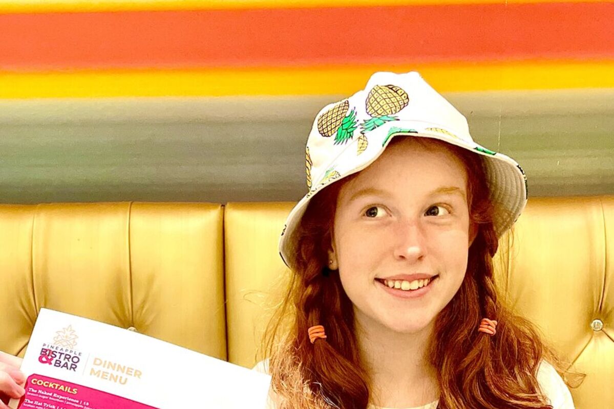 A%20girl%20holding%20the%20menu%20for%20the%20dining%20area%20at%20The%20Maxwell%20Hotel