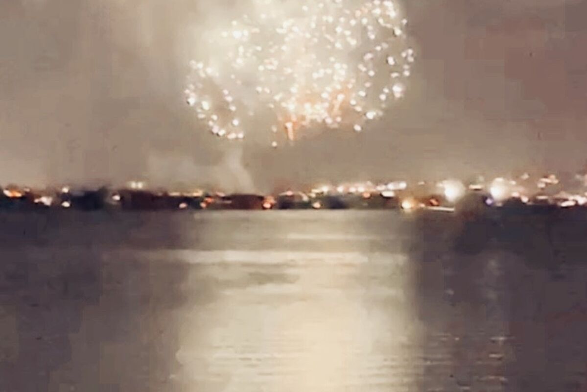 Fireworks%20going%20off%20in%20the%20distance%20with%20a%20girl%20sitting%20nearby%2E