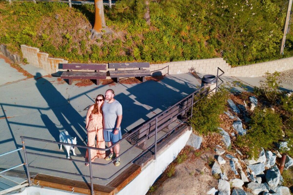 Couple%20with%20dog%20standing%20on%20a%20dock%20near%20a%20lake
