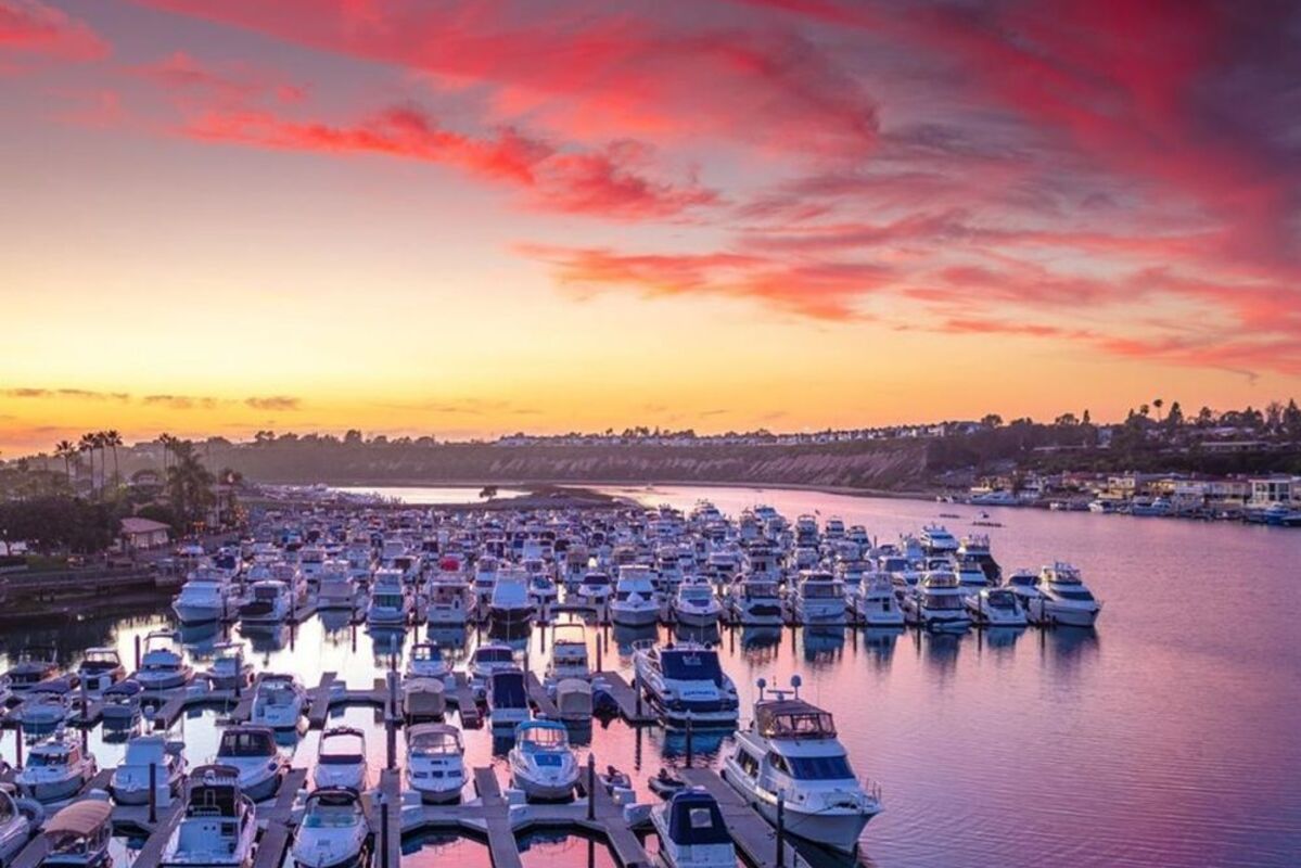 A%20pink%20and%20yellow%20sunset%20over%20the%20marina%20full%20of%20boats
