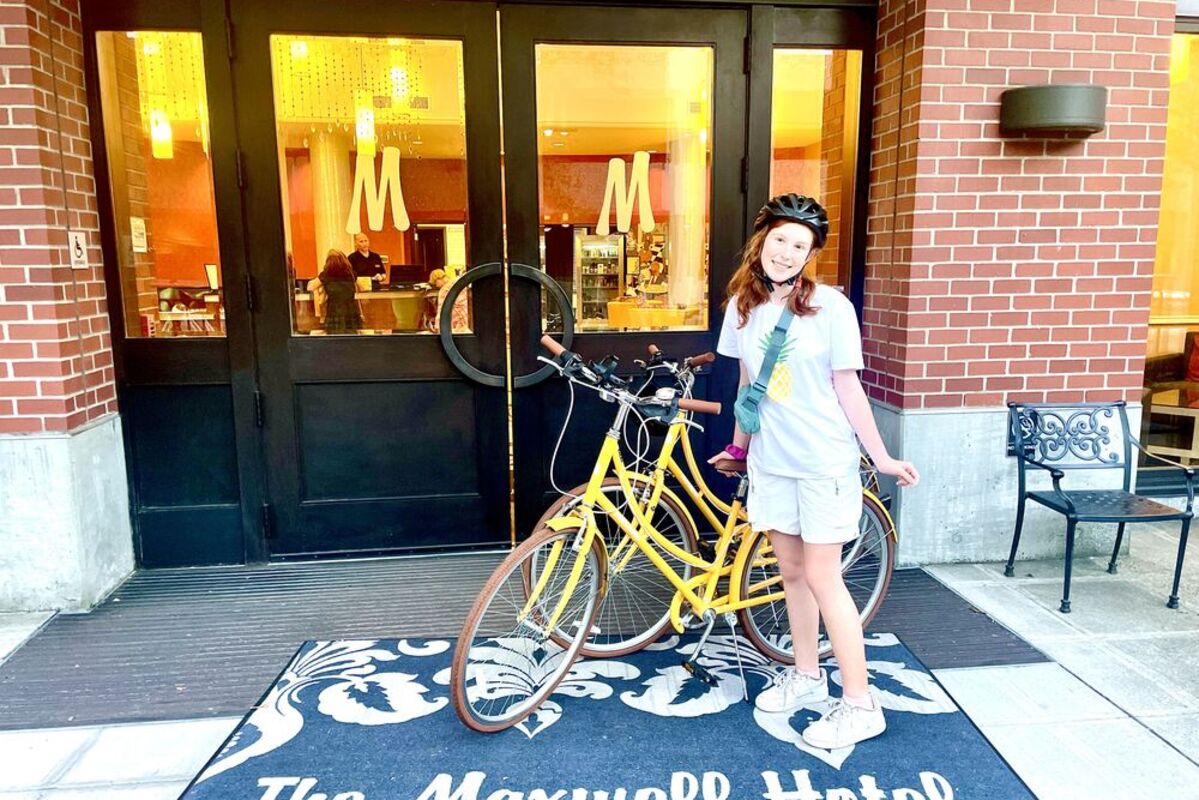 Girl%20in%20front%20of%20The%20Maxwell%20Hotel%20with%20a%20yellow%20beach%20cruiser%2E