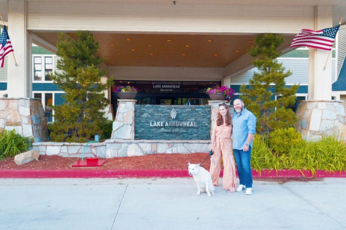 a%20couple%20with%20dog%20standing%20in%20front%20of%20resort